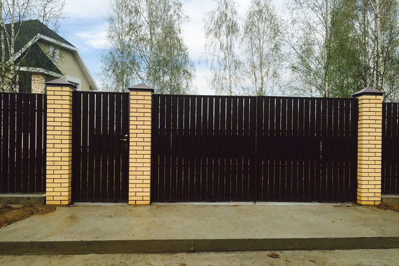 Забор из евроштакетника с кирпичными столбами фото и воротами