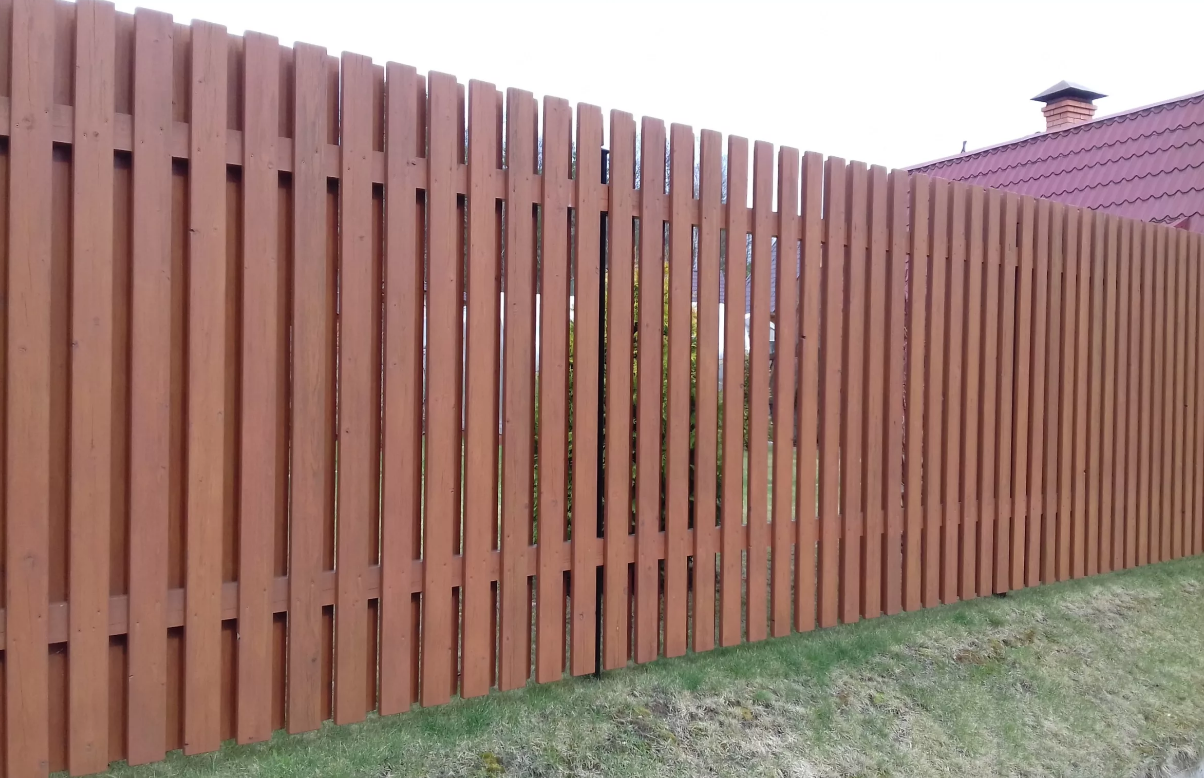 Деревянный забор на металлических столбах из обрезной доски фото